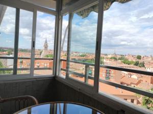 een kamer met ramen met uitzicht op de stad bij Apartamento Deluxe El Camino in Alcalá de Henares
