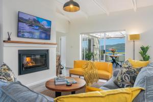 a living room with couches and a fireplace at Stunning Villa with pool and views of Knysna in Knysna
