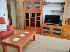 ein Wohnzimmer mit Fernseher und Couchtisch in der Unterkunft Apartamento Deluxe El Camino in Alcalá de Henares