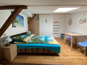 a bedroom with a bed with a blue comforter at Sea world Apartments Mansarda in Gdańsk
