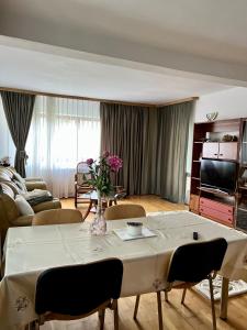 ein Wohnzimmer mit einem Tisch und einer Blumenvase in der Unterkunft Apartament Confort - Baile Olanesti in Băile Olăneşti