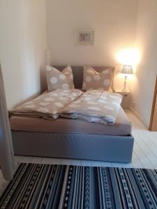 um quarto com uma cama com almofadas e um candeeiro em Martinsgarten em Angermünde
