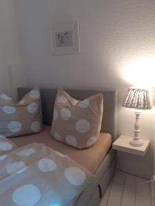 cama con almohadas y mesa con lámpara en Martinsgarten, en Angermünde