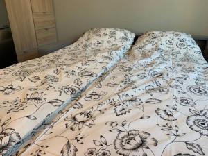 Una cama con una manta con flores. en Central 1 bedroom apartment NB!! Small room, en Oslo