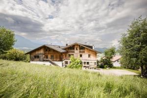 a house in the middle of a grassy field at Pension Haus Tirol in Laion