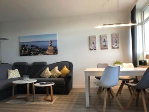 a living room with a couch and a table at Ferienwohnung Sandküste mit Strandkorb & Indoor Spielplatz in Heiligenhafen