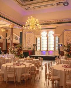 um salão de banquetes com mesas e cadeiras e um lustre em The Parr’s Bank Hotel em Warrington