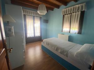 a bedroom with blue walls and a bed and a door at Acogedora casa en Onís - Cangas de Onis in Avín