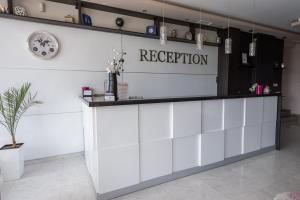 a white reception counter with a sign on the wall at Polina Beach in Sozopol