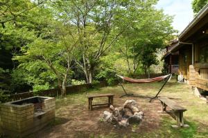 a hammock and a bench in a yard at Sunny Side Cottage in Shimoda