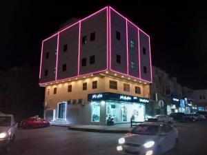a building is lit up with pink lights on it at عاليا للشقق والاجنحة المفروشة in Al Khobar