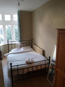 una cama con un animal de peluche blanco sobre ella en Bell House Hostel, en Londres