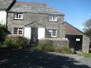 an old brick house with a gate and a driveway at Barton Cottage in Bude