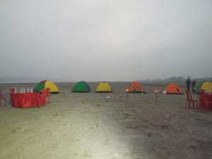 a group of tents on the beach in the fog at Jhoomke camping and water sports adventure in Auraiya