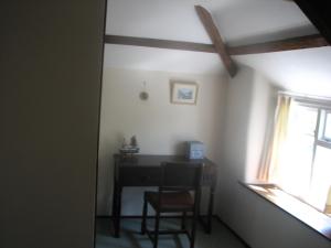 a room with a table and a chair and a window at Barton Cottage in Bude