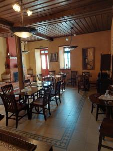 una sala da pranzo con tavoli e sedie in legno di House Mitsiou Traditional Inn a Arnaia