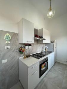 a kitchen with white cabinets and a stove top oven at Sweet home in Varese