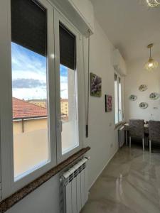 uma sala de estar com duas janelas e uma mesa com cadeiras em Sweet home em Varese