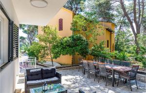 a patio with a table and chairs and a yellow building at Holiday Home Jadrija Vii Iii in Jadrija +24 photos