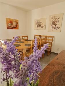 ein Esszimmer mit einem Tisch und lila Blumen in der Unterkunft Kuća za odmor Hodak in Plitvička Jezera