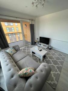 a living room with a couch and a tv at Comfy and Spacious Flat in London