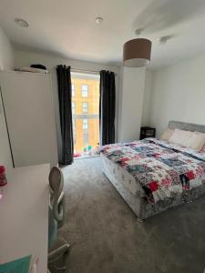 1 dormitorio con cama y ventana grande en Comfy and Spacious Flat, en Londres