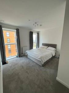 1 dormitorio con cama y ventana grande en Comfy and Spacious Flat, en Londres