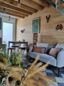 uma sala de estar com um sofá e uma mesa em Planchesdisa em Saint-Pair-sur-Mer