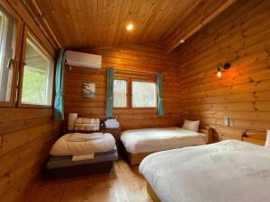 下田市にあるSunny Side Cottageの木造キャビン内のベッドルーム1室(ベッド2台付)