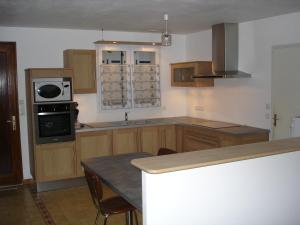 uma cozinha com armários de madeira e uma bancada em Maison 5 personnes à Noirmoutier em Noirmoutier-en-l'lle