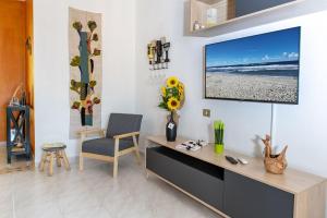 ein Wohnzimmer mit einem Flachbild-TV an der Wand in der Unterkunft Casa Elisa La Caletta in La Caletta