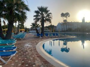 卡巴納斯·德·塔維拉的住宿－Beach House Golden Club，一个带躺椅的游泳池,棕榈树