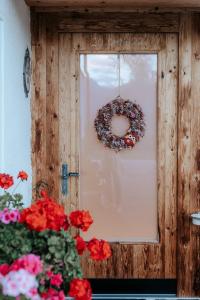 a wreath is hanging on a window with red flowers at AuerHias in St. Wolfgang