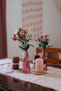 聖沃爾夫岡的住宿－AuerHias，一张桌子,上面有三个花瓶,里面装有鲜花