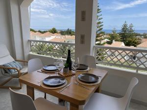 a dining room with a table and chairs and a balcony at Duplex en résidence privée, piscine, vue mer panoramique in Alcossebre