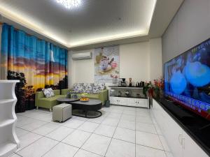 sala de estar con TV de pantalla plana grande en 箼篰斯民宿 en Fushi