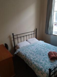 a bedroom with a bed and a desk and a window at Bell House Hostel in London