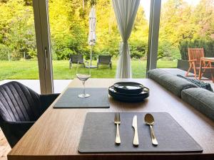 a wooden table with a glass of wine and silverware at Garden Apartment Untermühle in Bressanone