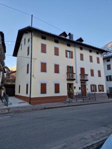 a white building on the side of a street at Casa Gion in Santo Stefano di Cadore