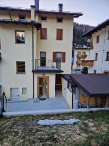 a large house with a balcony and a courtyard at Casa Gion in Santo Stefano di Cadore