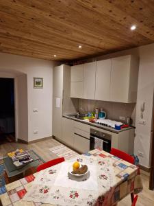 a kitchen with a table and a kitchen with white cabinets at Casa Gion in Santo Stefano di Cadore