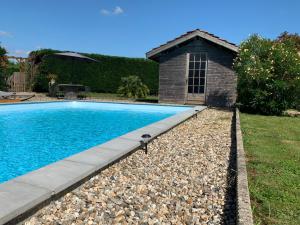 a swimming pool in a yard next to a house at Gîte ferme équestre avec piscine in Castex