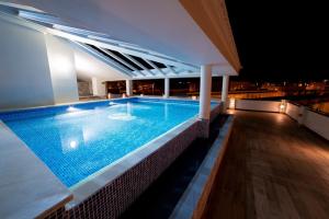 una piscina en la parte superior de un edificio por la noche en Puerta Salinas Isla Cristina, en Isla Cristina
