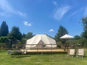 una grande tenda bianca con sedie e tavolo di Hope Cottage Bell Tent Retreat ad Ashbourne