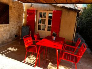 czerwony stół i krzesła na patio w obiekcie Maison avec patio et jacuzzi w mieście Saint-Rémy-de-Provence