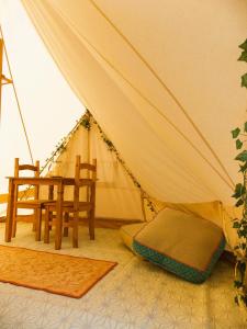 a tent with a chair and a table in it at Hope Cottage Bell Tent Retreat in Ashbourne