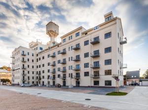 Biały budynek z wieżą wodną na górze w obiekcie Apartment YELLOW ROSE, Perfect Location with Free Parking, 24h Checkin & Balcony w Pieszczanach