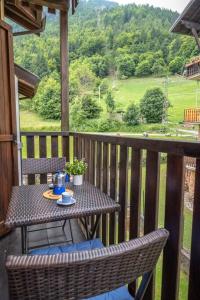 a table and chairs on a porch with a view at Happy Guest Apartments - Alpin Vista Colere in Colere