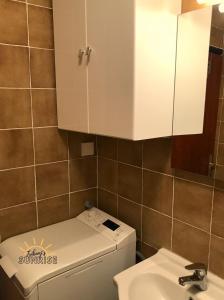 ein Badezimmer mit einem weißen Schrank über einem WC und einem Waschbecken in der Unterkunft Tribunj Sunrise in Tribunj