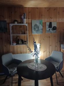 Una habitación con una mesa con un jarrón de flores. en Margarita's cottage, en Jūrmala